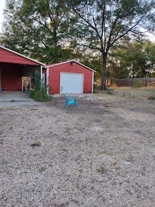 view of yard with a garage and an outbuilding