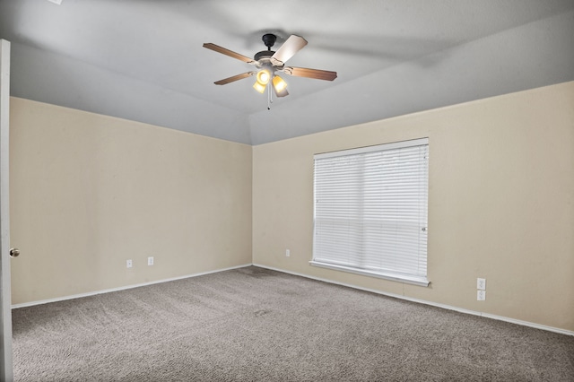 carpeted spare room with ceiling fan and vaulted ceiling