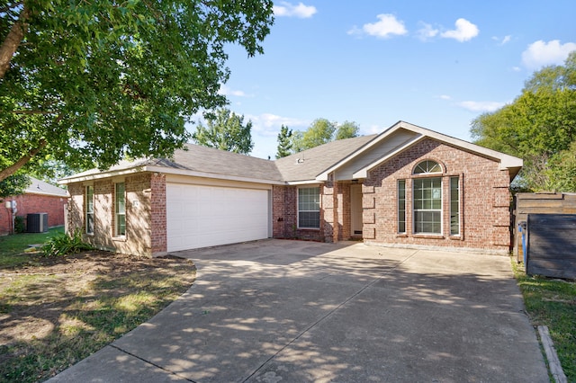 ranch-style house with central air condition unit and a garage