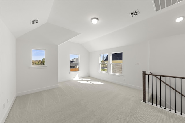 bonus room with light colored carpet, vaulted ceiling, and a healthy amount of sunlight