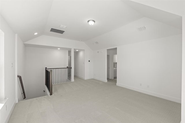 unfurnished room with light colored carpet and vaulted ceiling