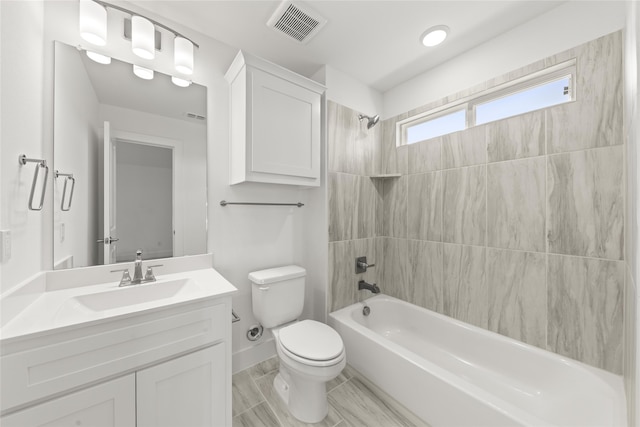 full bathroom featuring toilet, vanity, and tiled shower / bath