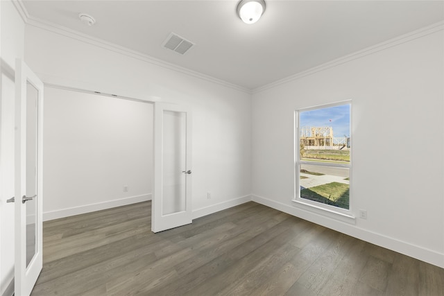 unfurnished room featuring ornamental molding and dark wood-type flooring