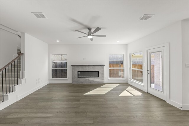 unfurnished living room with ceiling fan, dark hardwood / wood-style flooring, and a premium fireplace