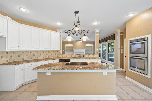 kitchen featuring dark stone counters, light tile patterned flooring, decorative backsplash, and a sink