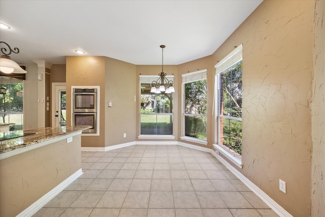 unfurnished dining area featuring light tile patterned flooring and a chandelier