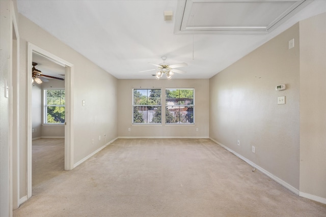 spare room with ceiling fan, a healthy amount of sunlight, and light colored carpet