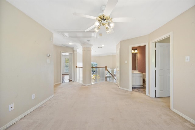 unfurnished room with a ceiling fan, baseboards, light carpet, and attic access