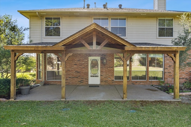 back of property featuring a yard and a patio area