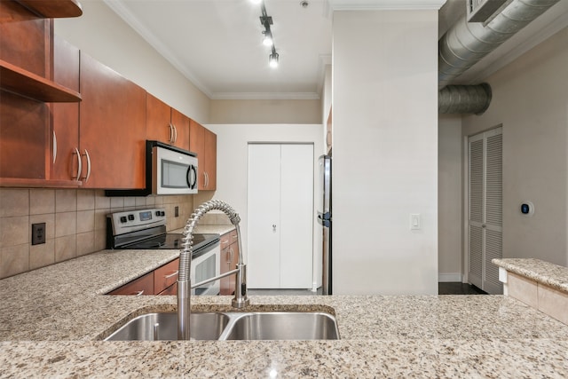 kitchen featuring light stone countertops, stainless steel appliances, ornamental molding, and sink