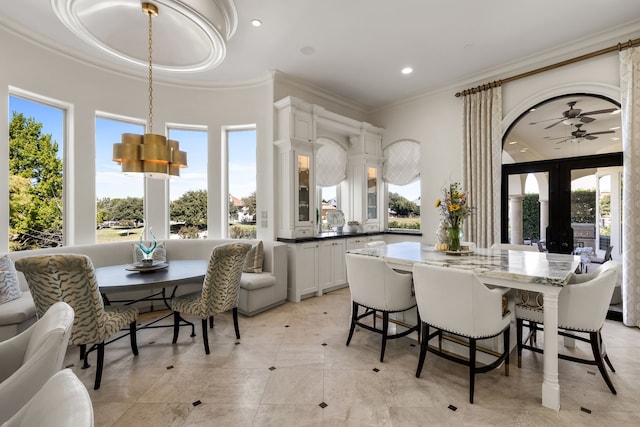 dining space featuring crown molding, french doors, ceiling fan with notable chandelier, and light tile patterned floors