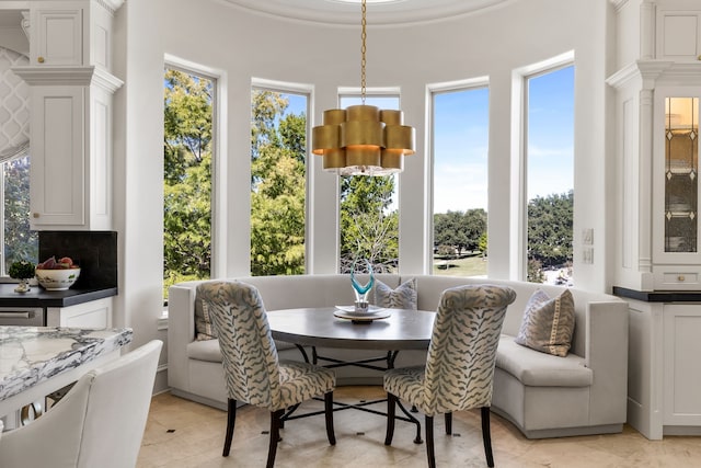 tiled dining room featuring a wealth of natural light and a notable chandelier