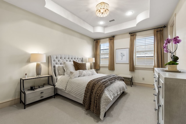 carpeted bedroom featuring a raised ceiling