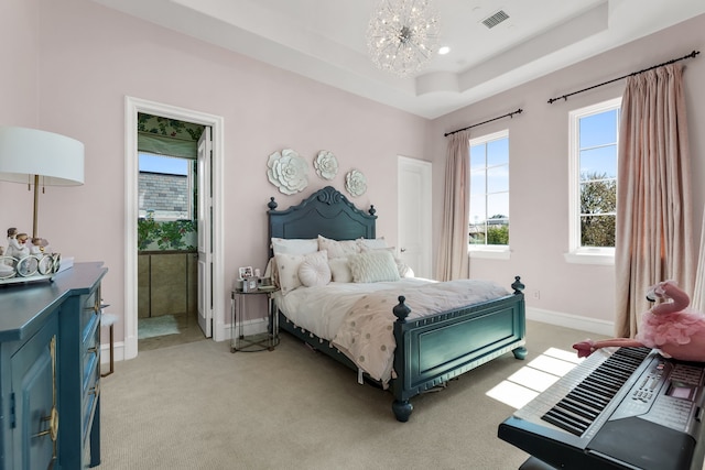 carpeted bedroom with a notable chandelier and a raised ceiling