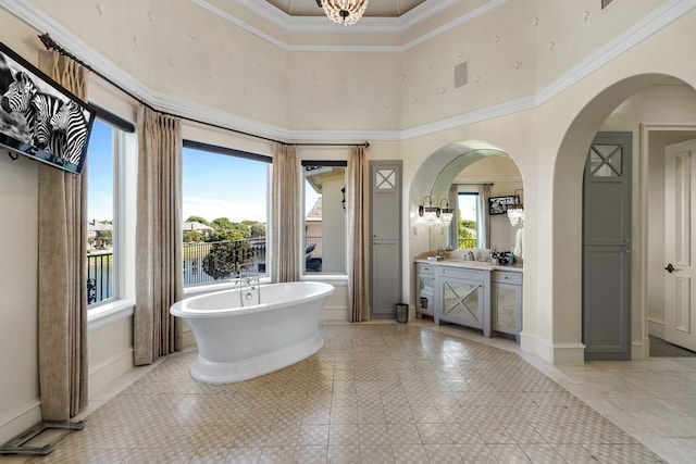 bathroom featuring a towering ceiling, crown molding, vanity, and a washtub