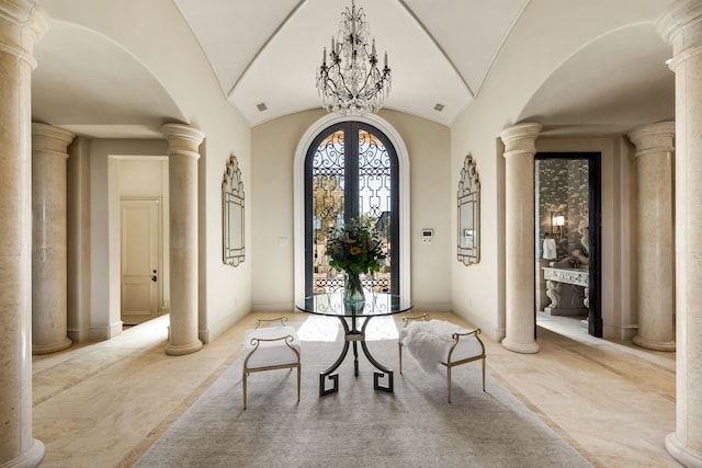 entrance foyer with vaulted ceiling, a notable chandelier, ornate columns, and a healthy amount of sunlight