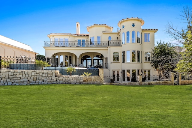 rear view of property featuring a yard and a balcony