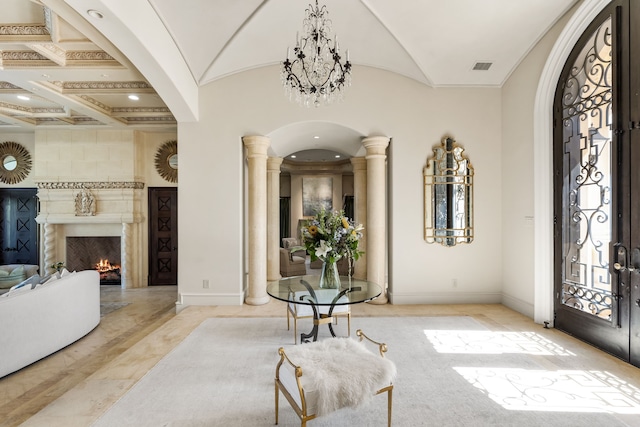 entryway featuring a notable chandelier, ornate columns, coffered ceiling, and beamed ceiling