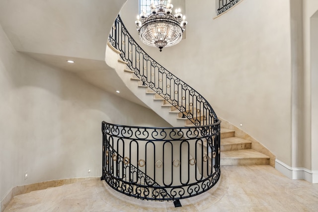 stairway with a high ceiling and a chandelier