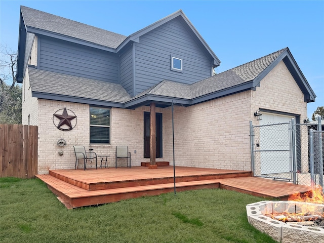 back of house featuring a garage, a yard, and a wooden deck