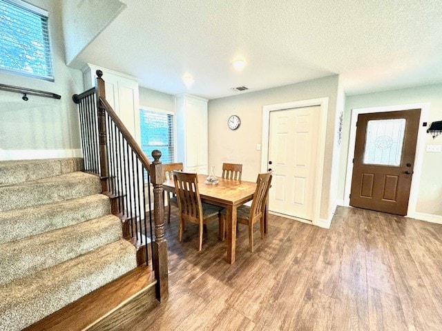 dining area featuring a textured ceiling and light wood-type flooring