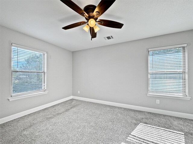 carpeted bedroom with two closets, a textured ceiling, and ceiling fan