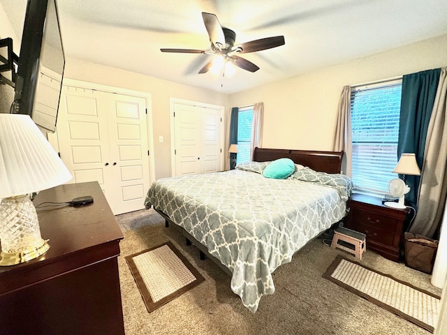 carpeted bedroom with two closets and ceiling fan