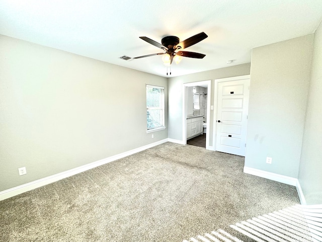 unfurnished bedroom featuring ceiling fan, carpet flooring, and ensuite bath