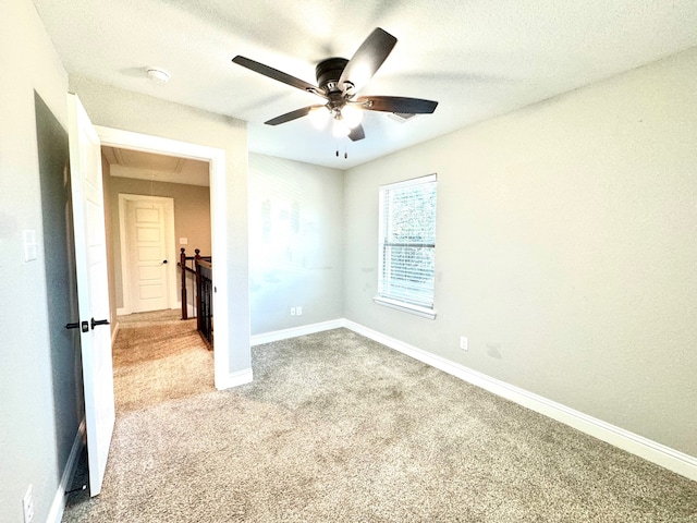 empty room featuring light carpet, a textured ceiling, and ceiling fan