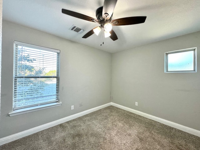 carpeted spare room featuring ceiling fan and a textured ceiling