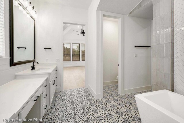 bathroom featuring a tub, ceiling fan, a textured ceiling, toilet, and vanity