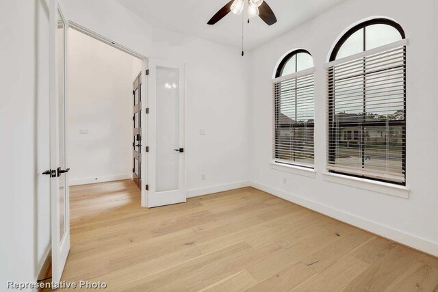 spare room featuring ceiling fan and light hardwood / wood-style flooring