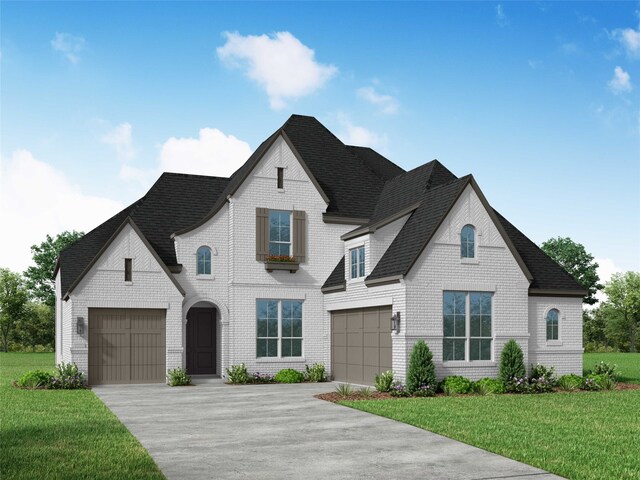 french country style house featuring a front lawn and a garage