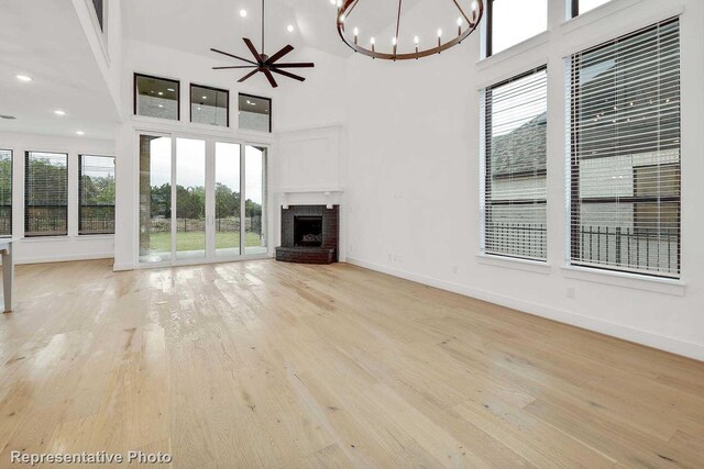 unfurnished living room featuring light hardwood / wood-style flooring, high vaulted ceiling, and a wealth of natural light