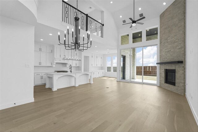 spare room featuring light hardwood / wood-style floors, high vaulted ceiling, and ceiling fan