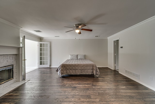 bedroom with ornamental molding, dark hardwood / wood-style floors, a tile fireplace, and ceiling fan