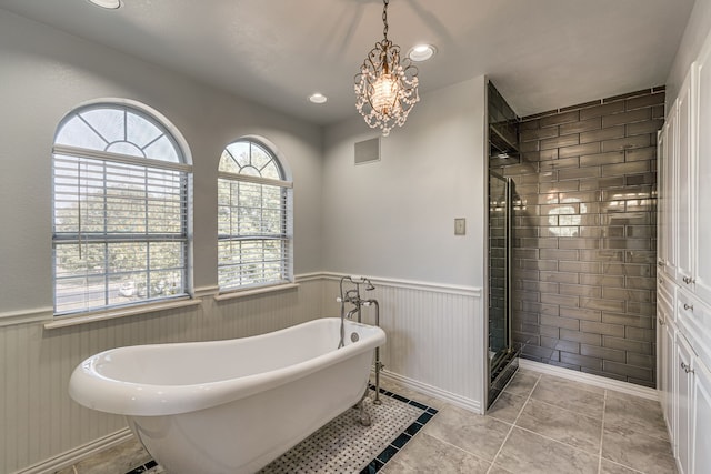 bathroom featuring independent shower and bath, an inviting chandelier, and tile patterned flooring