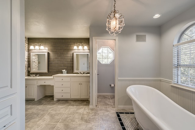 bathroom with backsplash, a washtub, an inviting chandelier, vanity, and a textured ceiling