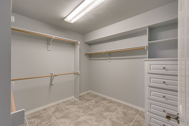 walk in closet featuring light tile patterned flooring