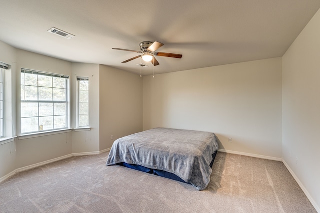 bedroom with ceiling fan and light colored carpet