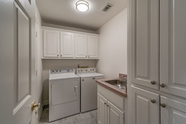 washroom featuring sink, cabinets, and separate washer and dryer