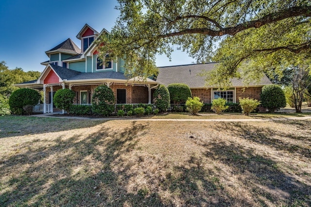 view of front of house with a front yard and covered porch