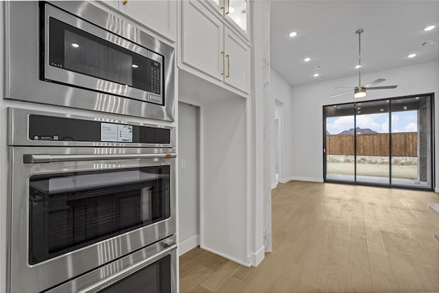 kitchen featuring white cabinets, light hardwood / wood-style floors, ceiling fan, and stainless steel appliances