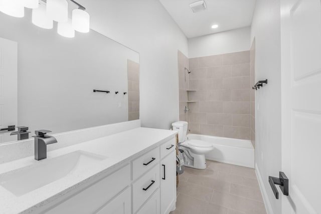 full bathroom featuring tile patterned floors, tiled shower / bath combo, toilet, and vanity