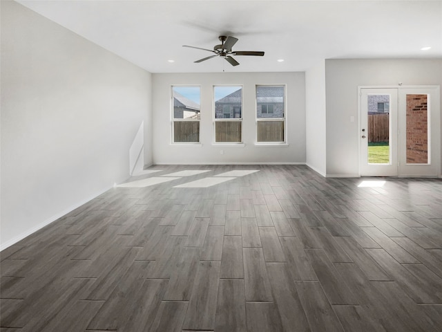 unfurnished living room featuring ceiling fan and dark hardwood / wood-style flooring