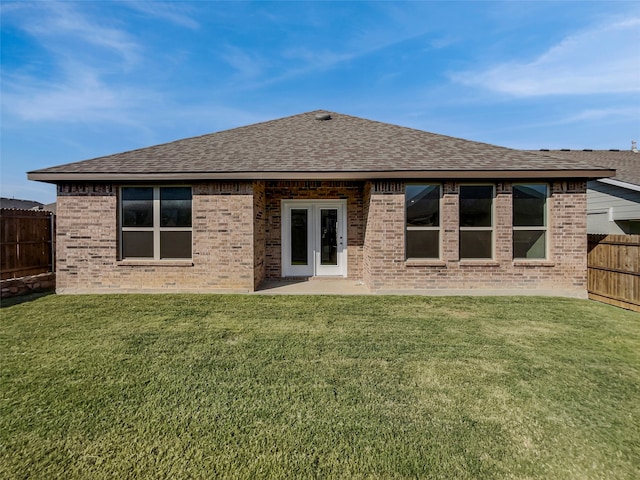 rear view of property with a patio and a lawn