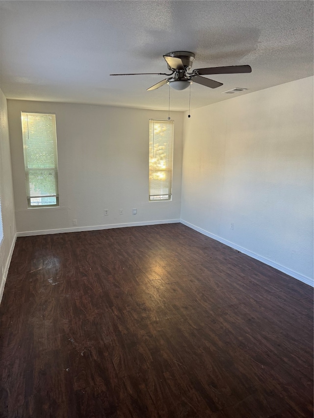 unfurnished room with ceiling fan, a textured ceiling, and dark hardwood / wood-style flooring