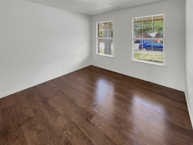 empty room with dark hardwood / wood-style flooring