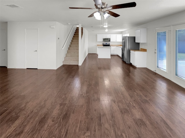 unfurnished living room featuring ceiling fan and dark hardwood / wood-style floors