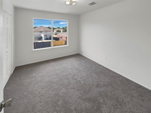 unfurnished room with dark carpet